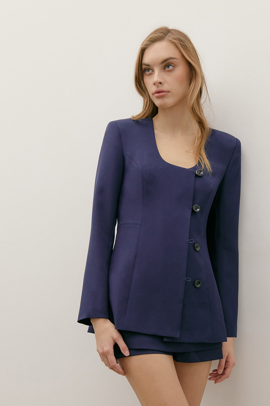The deep navy hue adds versatility and sophistication, making this piece a polished essential for elevated daywear and modern evening styling alike.