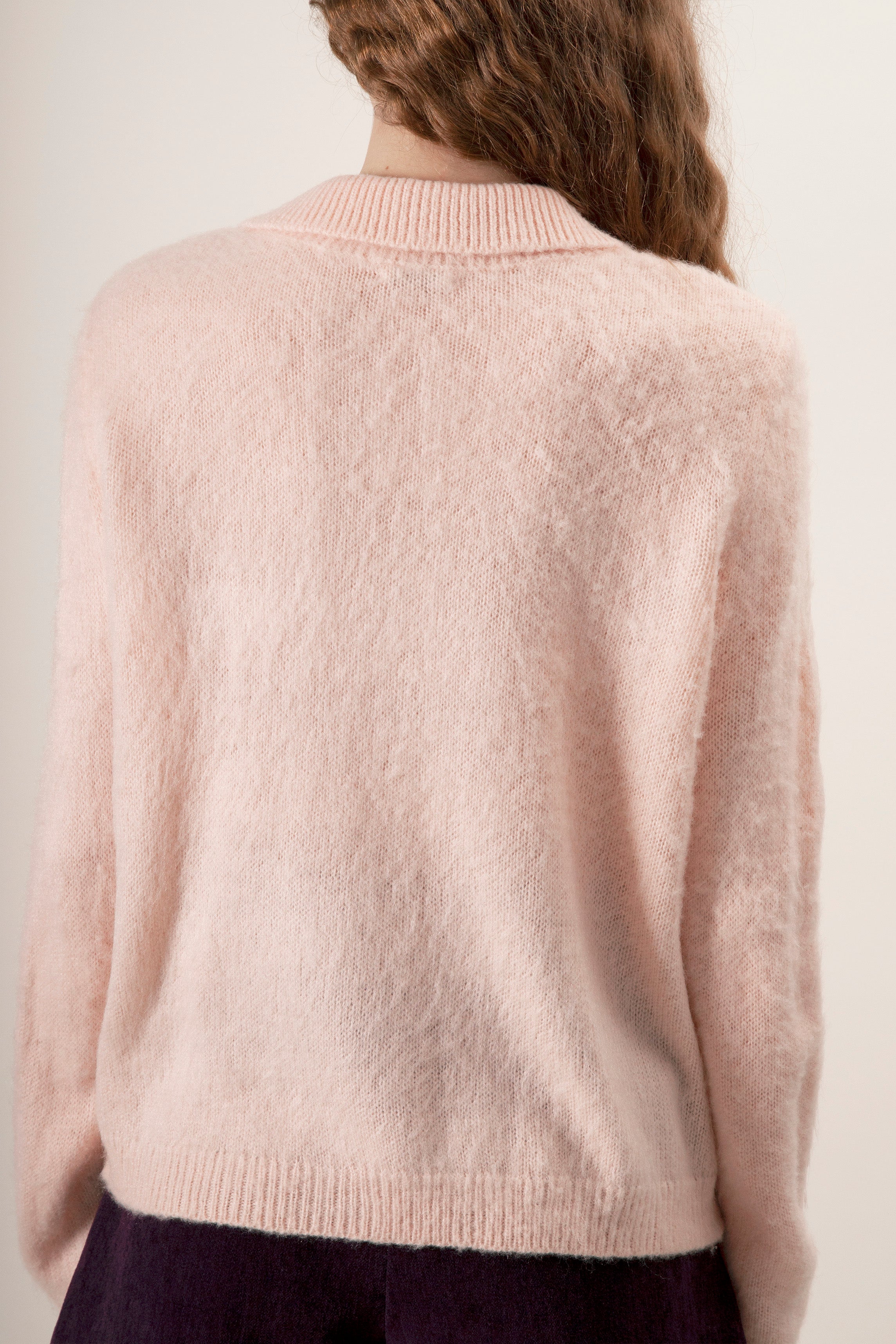 Featuring a classic collar, gold-tone button closure, and front patch pockets, this cardigan blends traditional tailoring with modern softness.