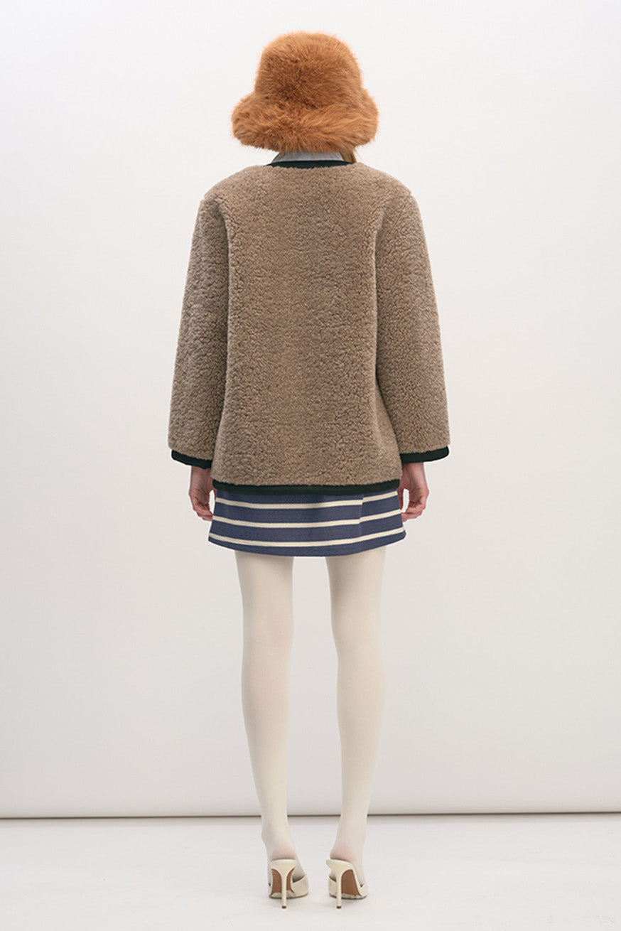 Crafted from a soft, textured shearling-style fleece, this jacket delivers warmth without bulk while maintaining a clean, structured silhouette.