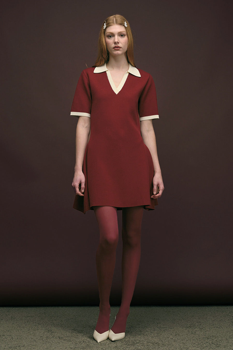 This refined shirt dress is crafted in a rich burgundy hue, defined by its clean lines and understated elegance.