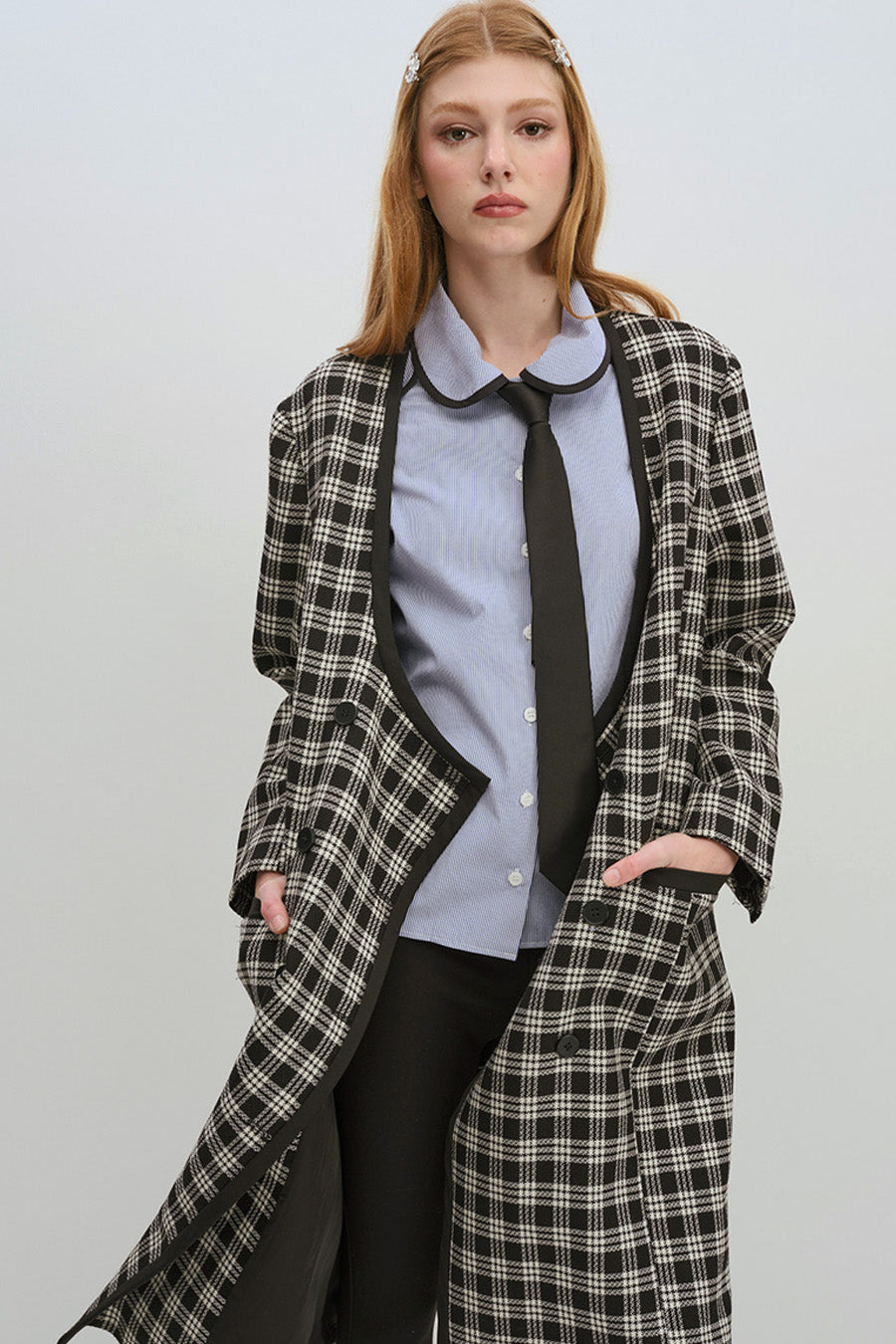 The silhouette is defined by a sculptural contrast collar with soft curves and coordinating contrast cuffs, lending a modern, architectural finish.