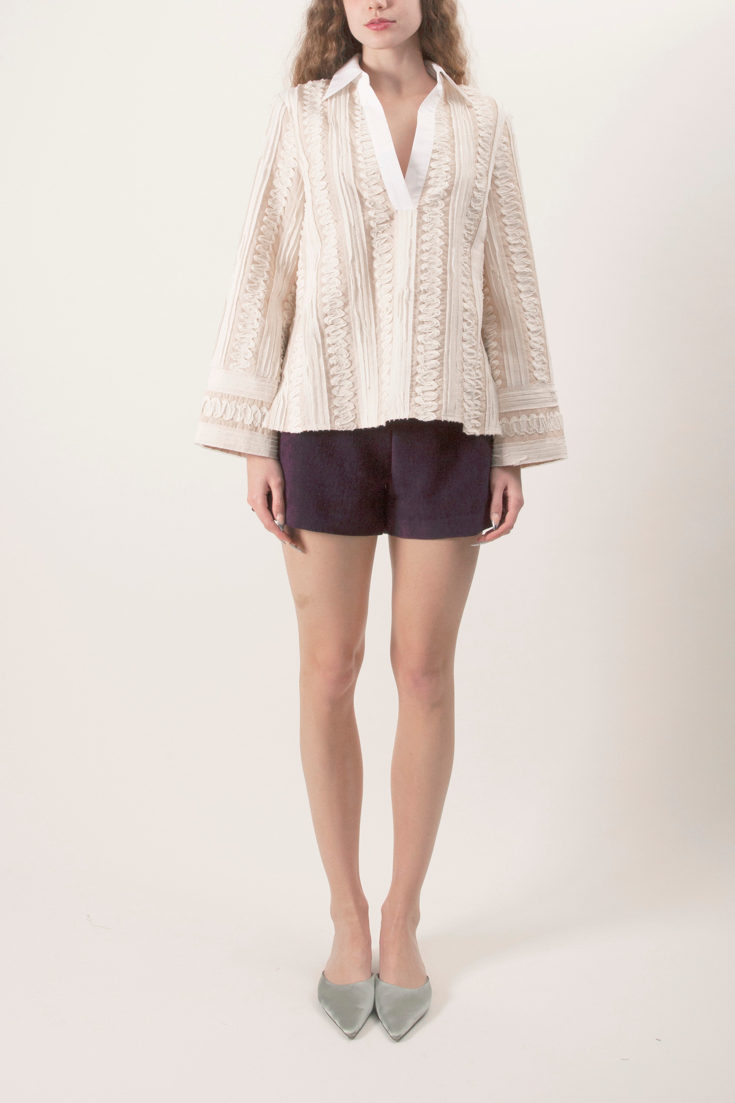 A refined expression of modern elegance, this luxury blouse is crafted in an intricate lace fabrication that balances softness with structure.