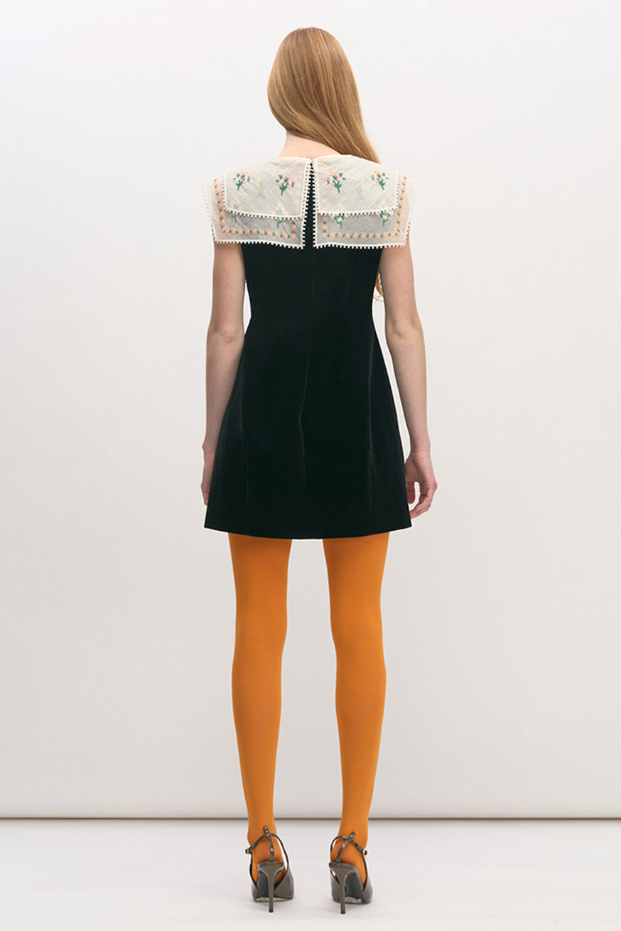 Sleeveless and softly structured, the dress balances graphic simplicity with romantic detailing, making it a distinctive piece for elevated daywear or modern evening styling.