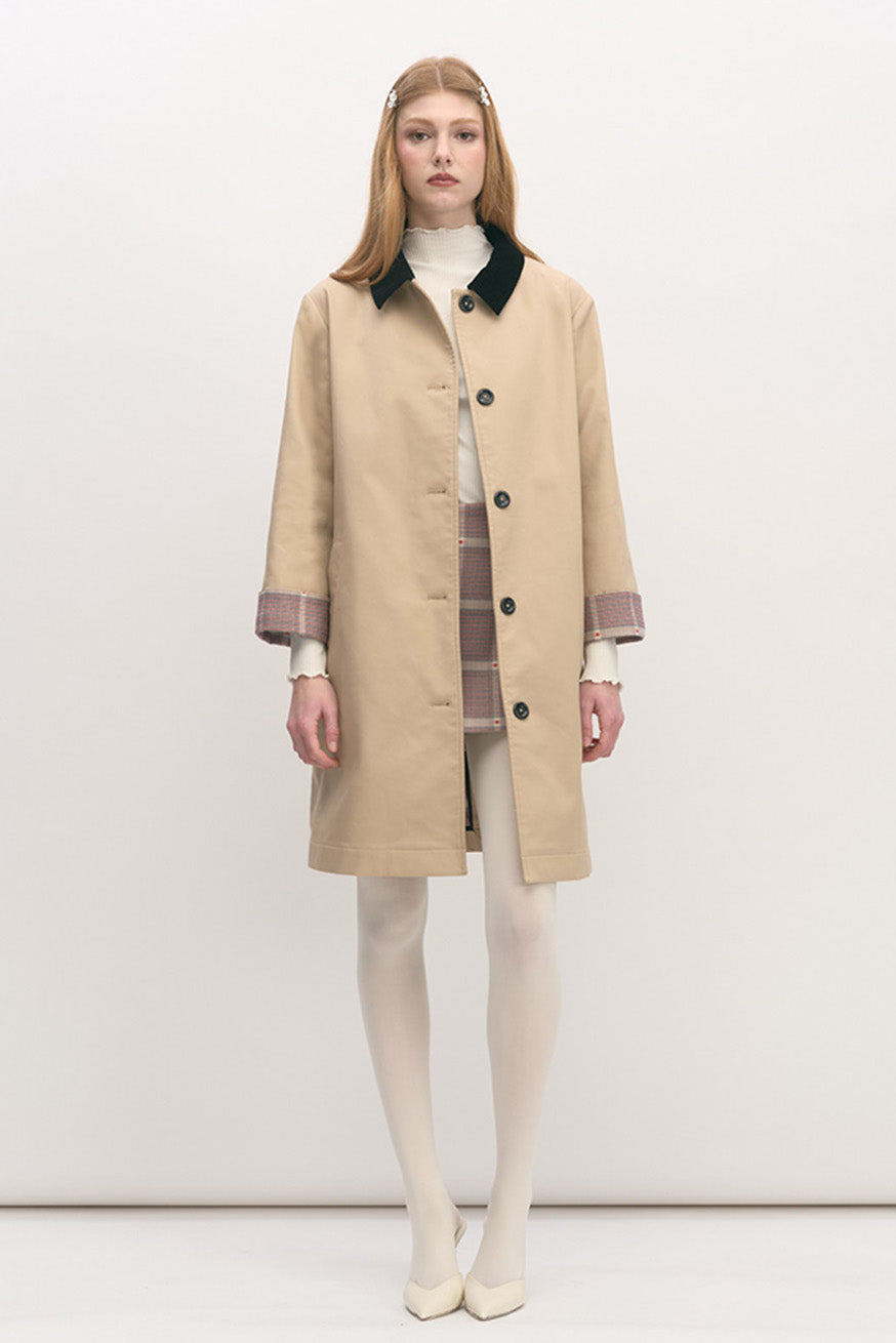This elegant coat is crafted in a refined beige fabrication, embodying timeless sophistication with modern restraint.