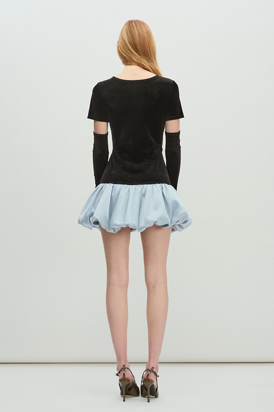 The short sleeves and clean round neckline keep the design minimal and balanced, allowing the statement skirt to take center stage.