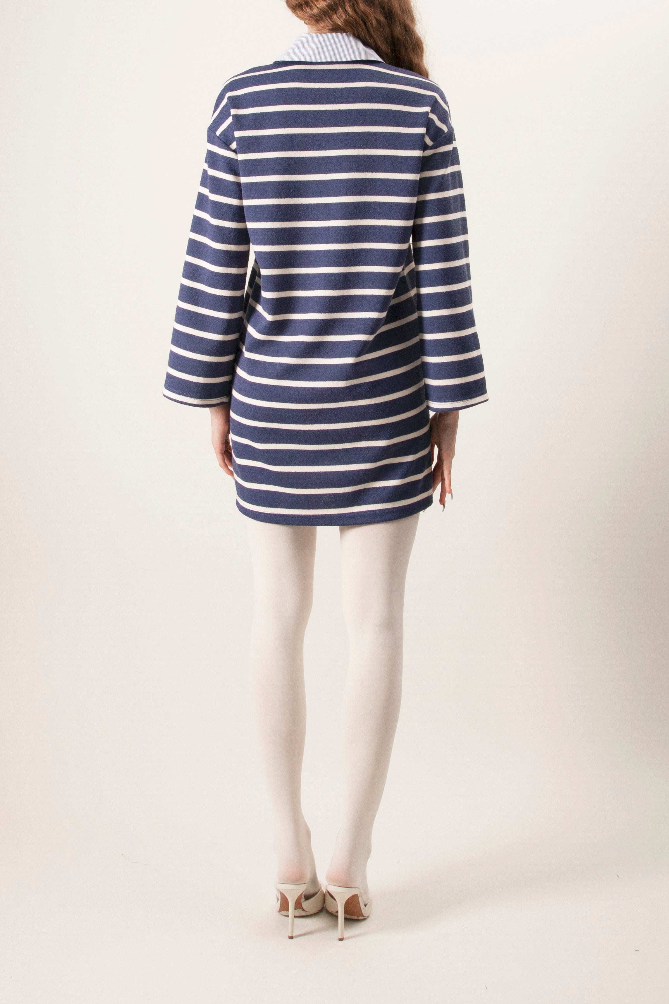 The polo-style collar with a partial button placket adds a refined touch, while the relaxed, tunic-length fit ensures comfort and easy layering.