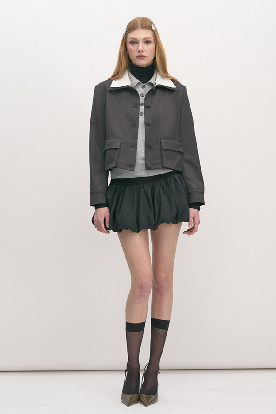 This impeccably tailored jacket is crafted in a refined charcoal tone, balancing structure with understated elegance.