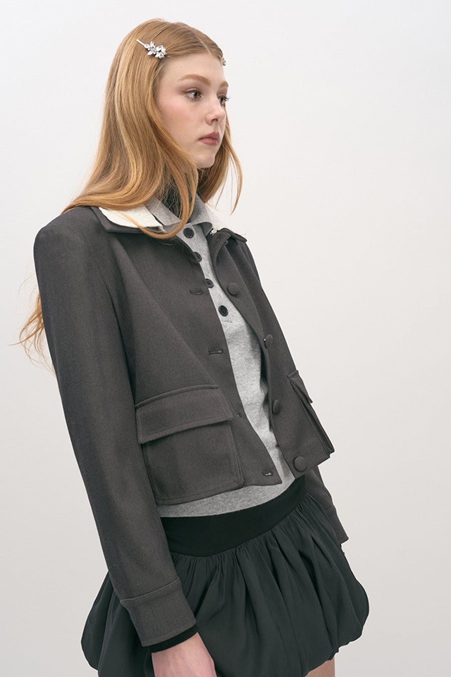 Designed with a cropped silhouette, it features a contrasting ivory collar that sharpens the look with modern sophistication.