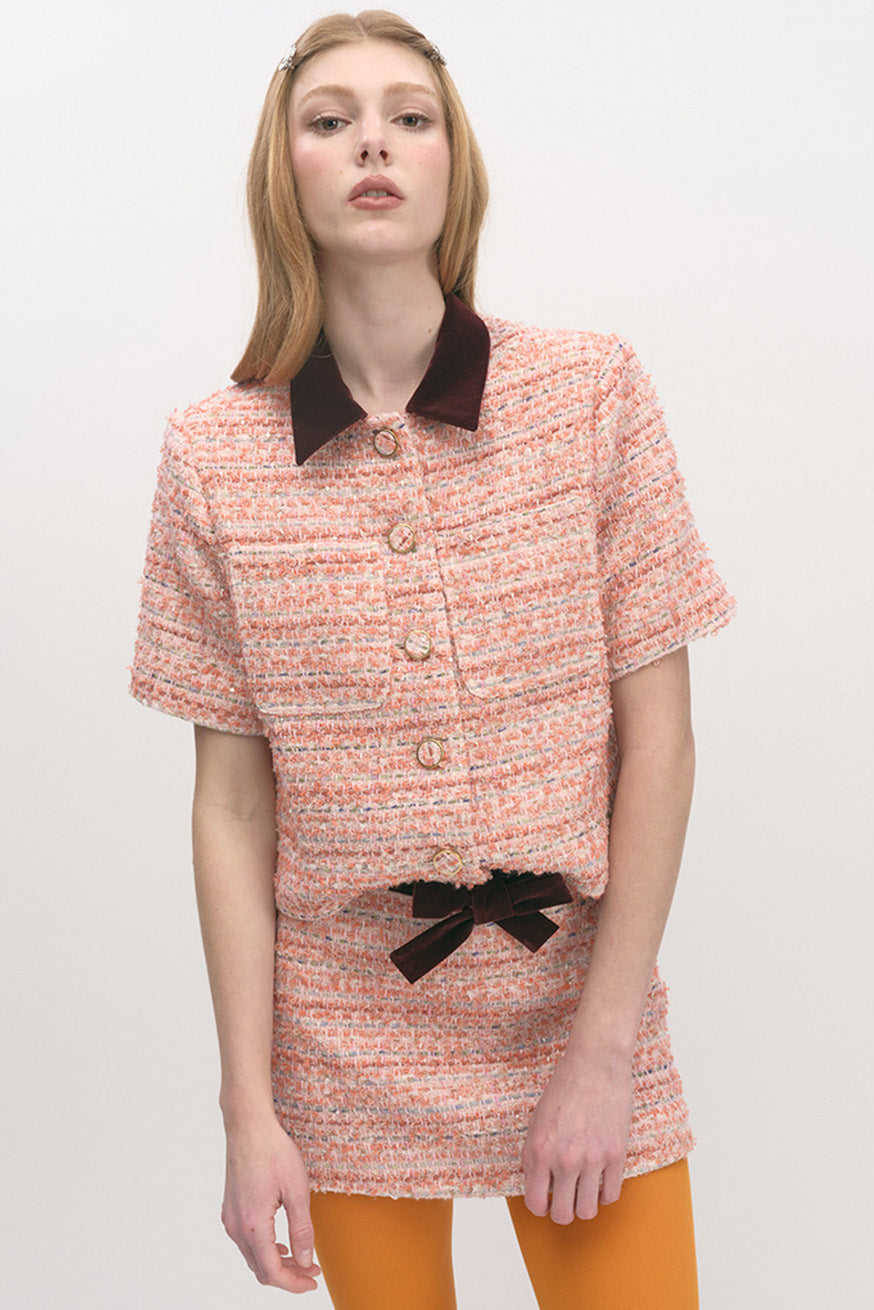 The design features a contrast pointed collar that adds a tailored, modern edge, along with a short-sleeve silhouette ideal for transitional seasons.