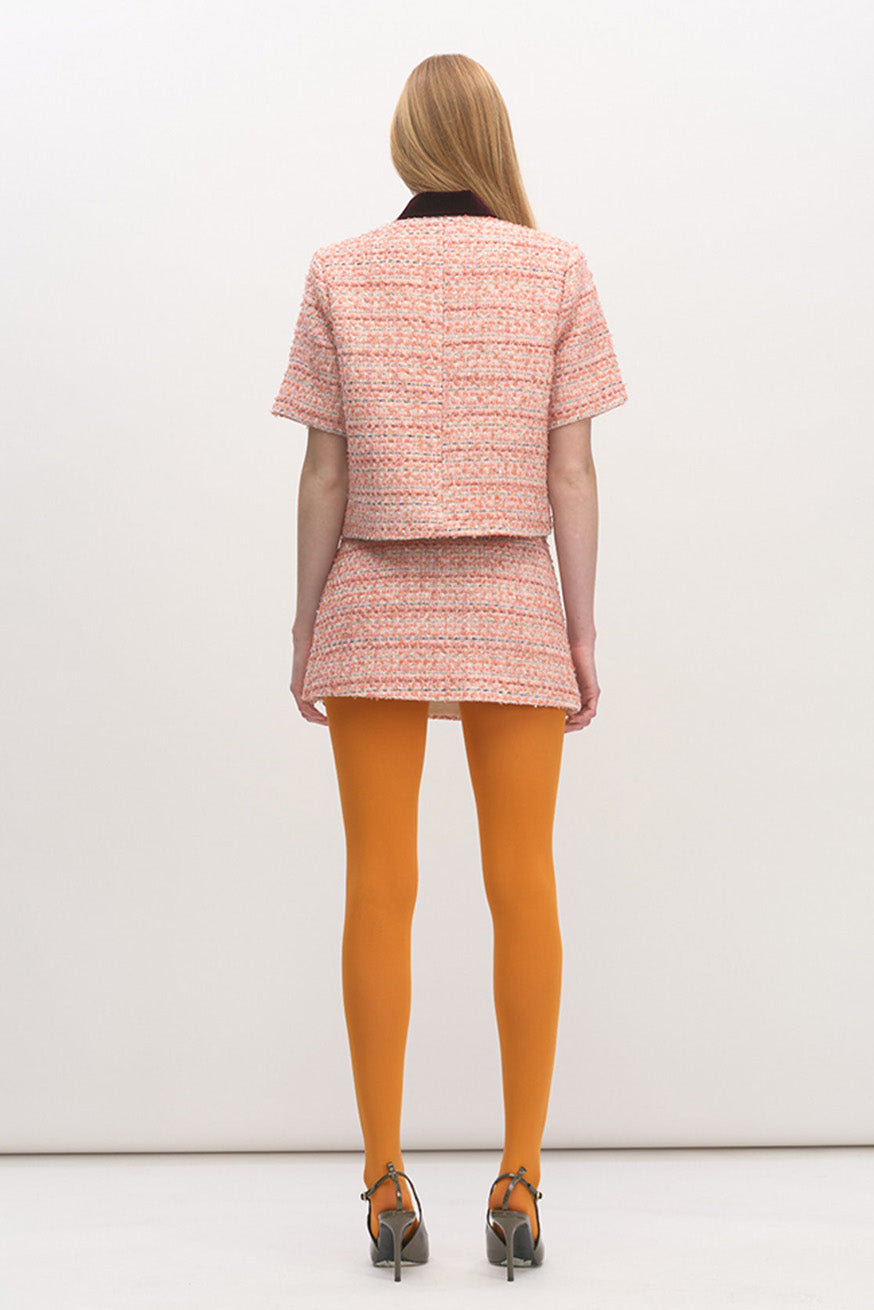 Crafted from a multi-tonal pink bouclé-style tweed, the top offers rich texture and a softly structured feel.