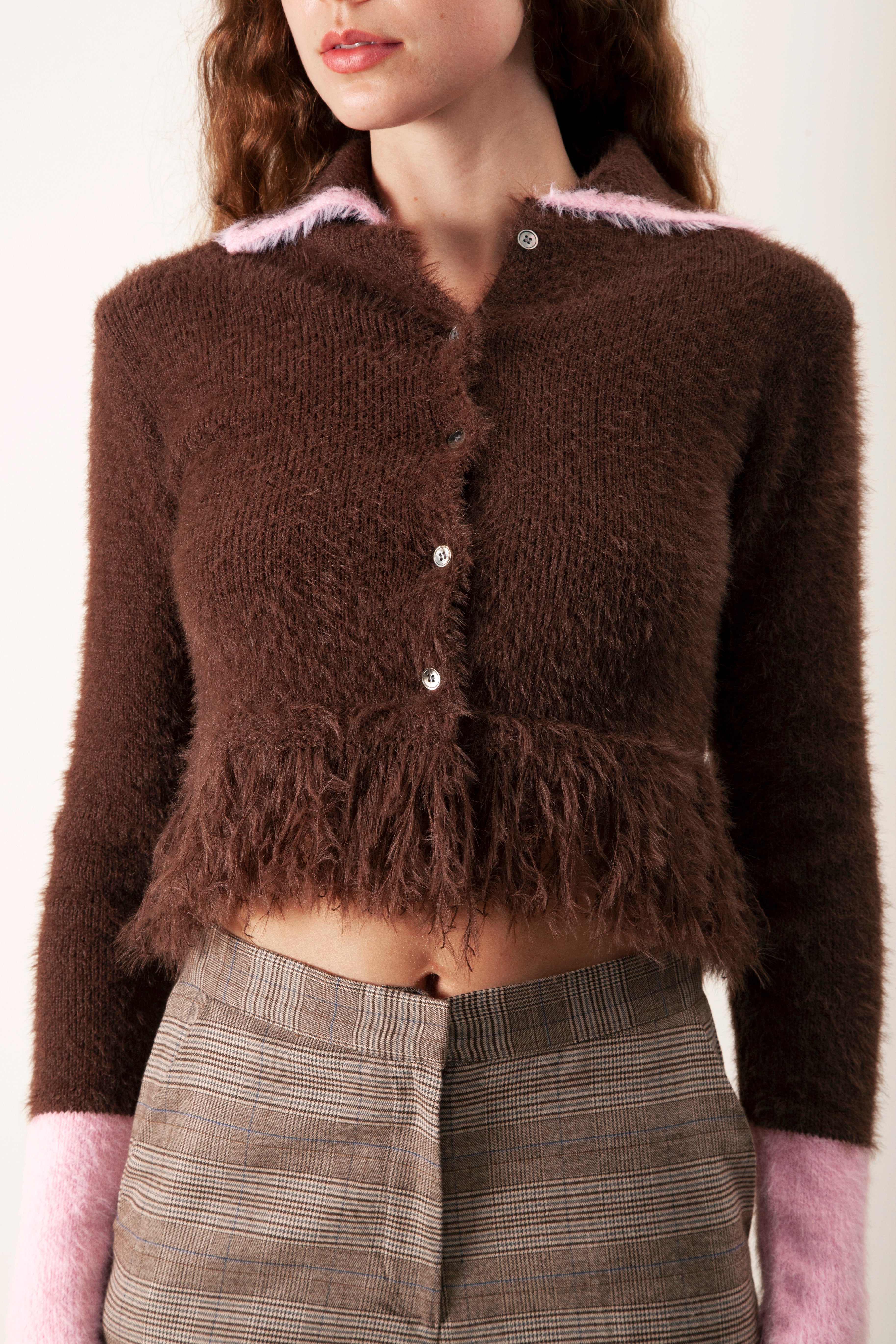 Soft, playful, and fashion-forward, this cropped knit cardigan brings a modern twist to a classic silhouette.