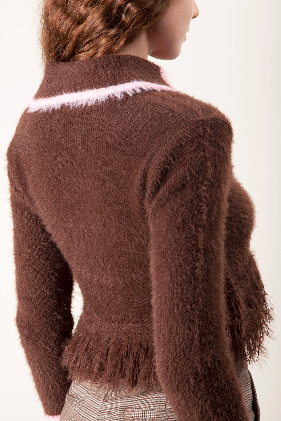Crafted from a fuzzy textured knit, the sweater features a fitted bodice that gently cinches at the waist before finishing with a subtle ruffled hem for a feminine, flattering shape.