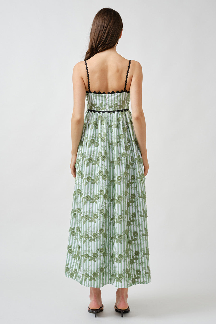 The vertical stripe motif is interwoven with intricate floral accents, creating a layered visual texture that elongates the silhouette and enhances movement