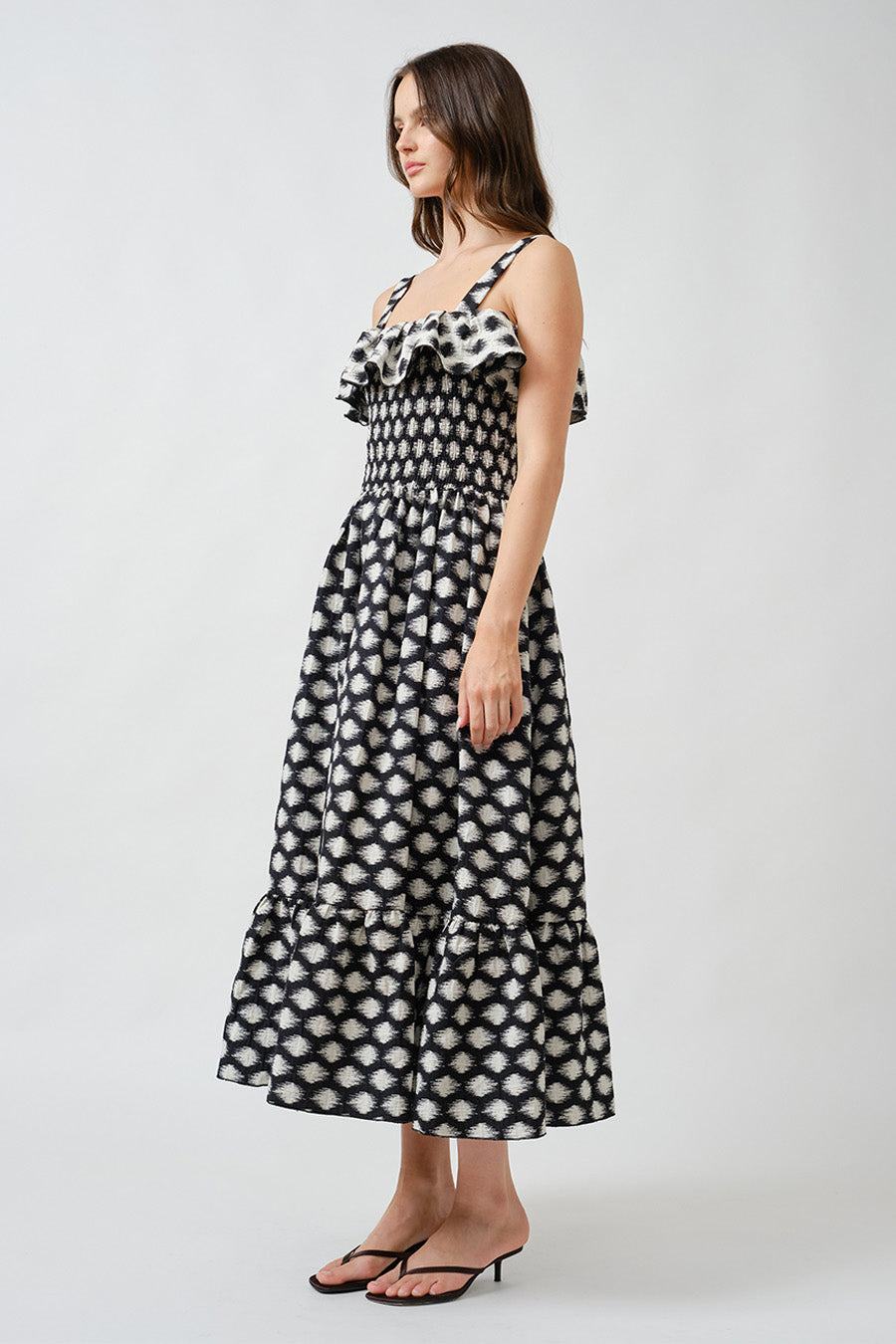 Delicate ruffle detailing along the neckline and hem adds dimension and movement, creating a romantic silhouette with modern appeal.