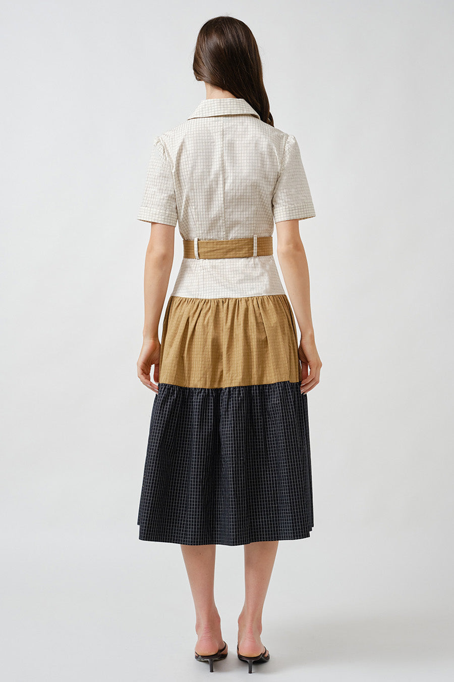 The skirt flows into a beautifully tiered, color-block design, blending soft neutral tones with deeper contrast for visual depth and architectural appeal.