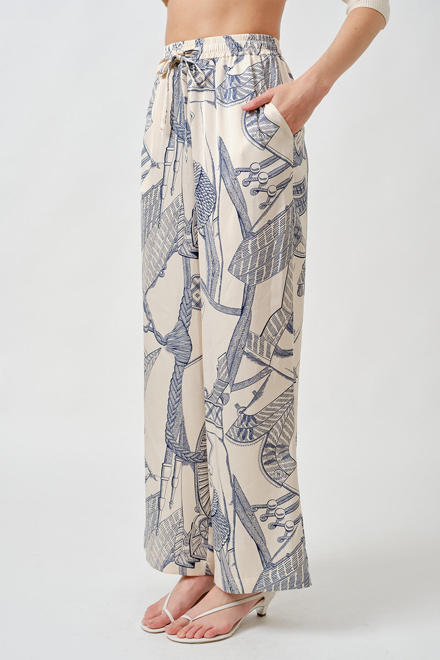 Crafted from a lightweight, fluid fabric, they feature a relaxed silhouette enhanced by an adjustable drawstring waist for refined comfort and versatility.