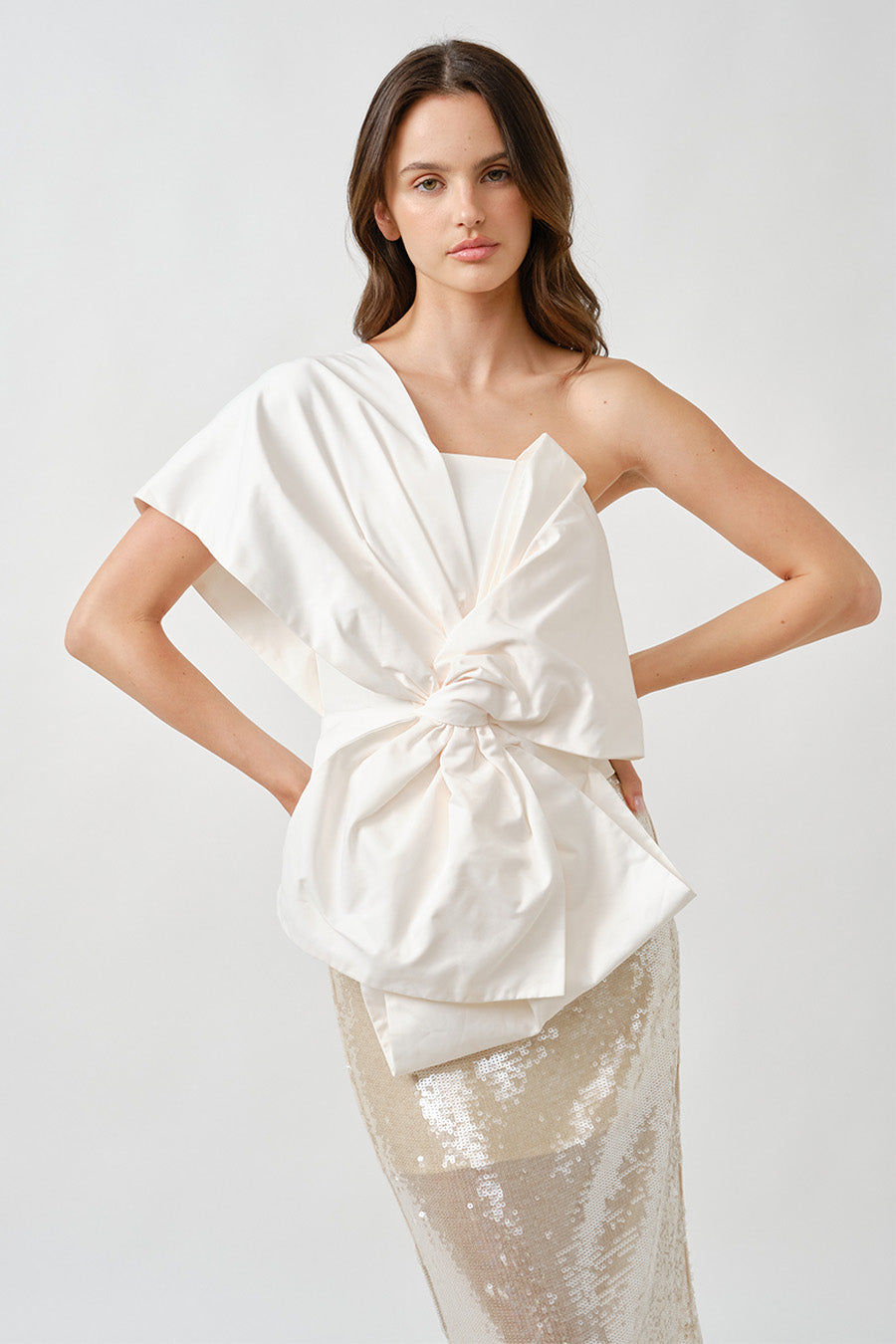 The asymmetrical neckline frames the shoulder beautifully, while the structured yet soft silhouette balances bold form with feminine grace.