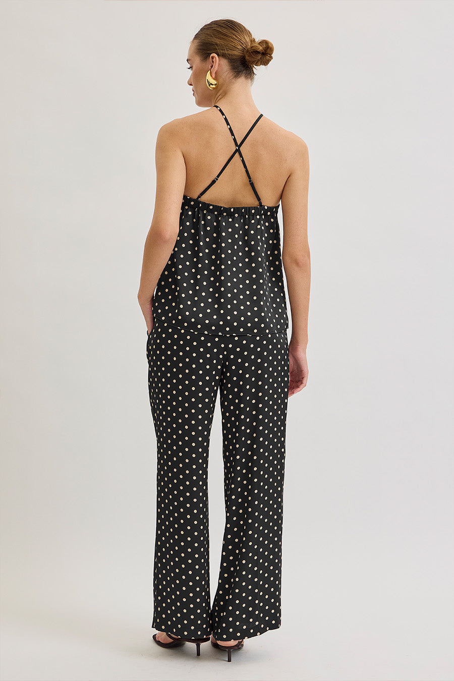 The classic black base is punctuated by delicate ivory dots, striking a balance between vintage charm and contemporary sophistication.