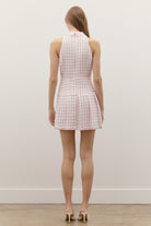 A collared neckline with a partial button front adds a polished, tailored finish, while the tiered mini skirt creates subtle volume and a playful, elevated feel.