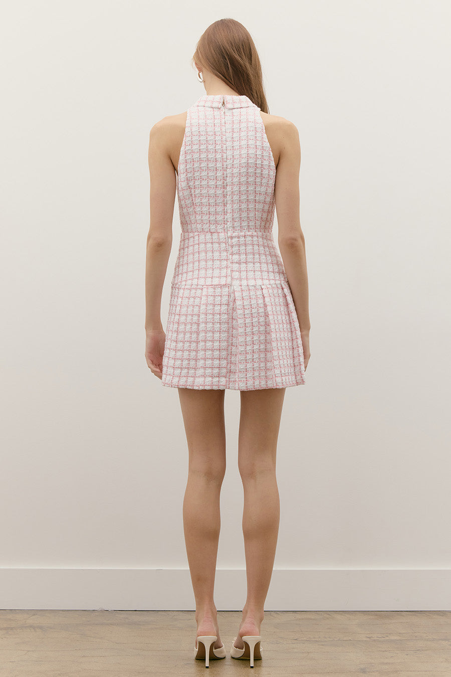 A collared neckline with a partial button front adds a polished, tailored finish, while the tiered mini skirt creates subtle volume and a playful, elevated feel.