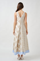 Finished with a soft contrast hem in pale blue, the dress reveals an unexpected detail that elevates its artisanal character.