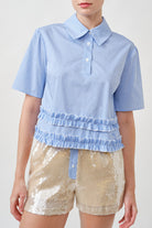 A modern reinterpretation of a classic silhouette, this gingham top blends crisp tailoring with playful refinement.