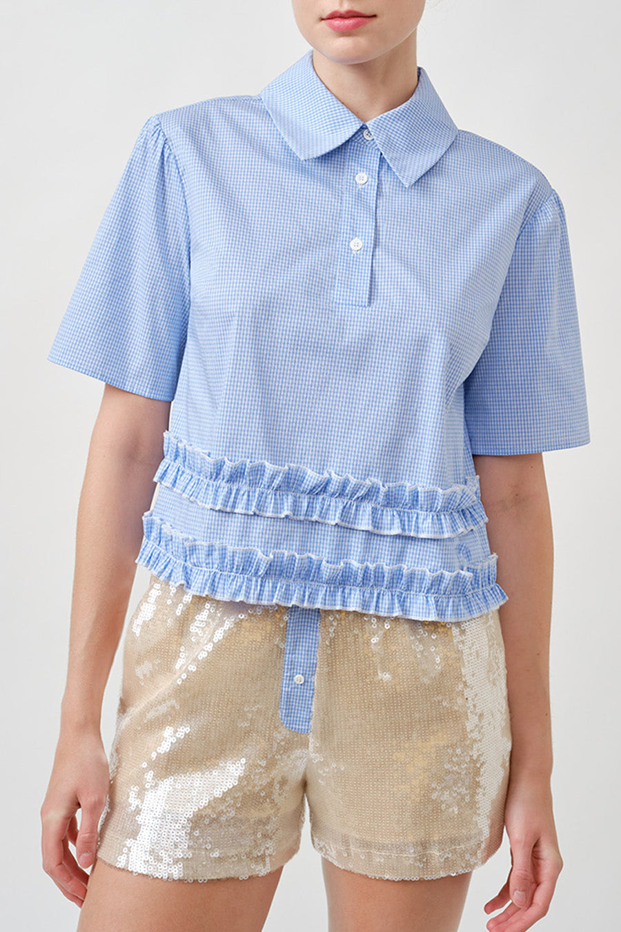 A modern reinterpretation of a classic silhouette, this gingham top blends crisp tailoring with playful refinement.