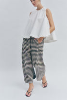 elevated by a refined black and sand gingham check that transcends seasonal trends.
