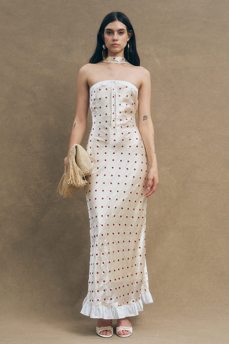 This romantic strapless maxi dress is crafted in an airy ivory fabrication, delicately adorned with embroidered red polka dots for a subtle touch of charm