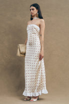 Designed with a softly structured bodice and refined front button detailing, the silhouette elongates the figure with graceful fluidity