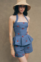 these crimson shorts blooms scattered across an indigo chambray ground, creating a striking contrast that commands attention